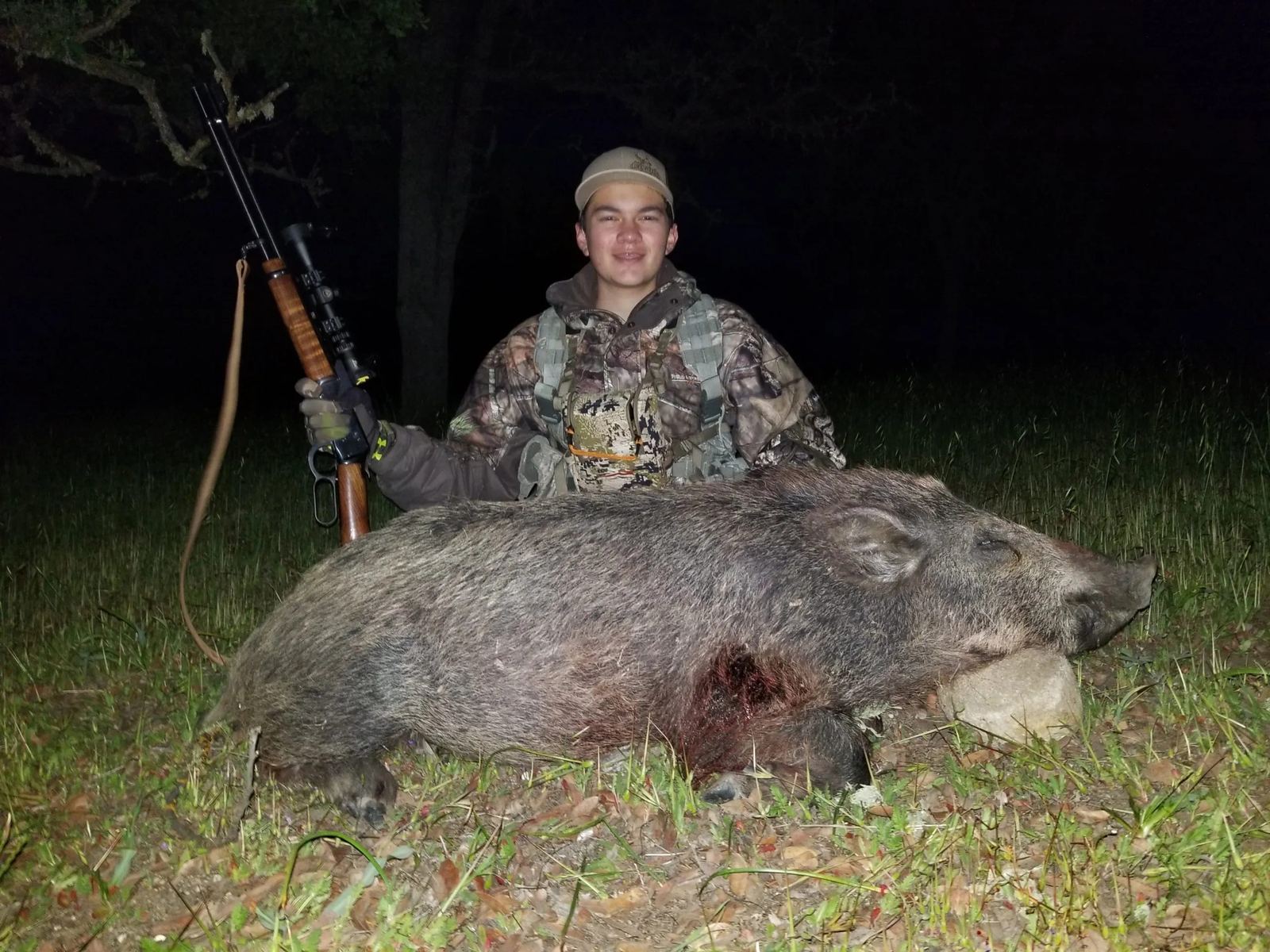 Young hunter with a wild pig on a night hunt