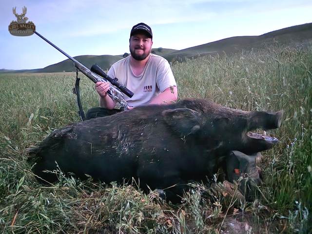 Hunter with a Central Coast wild pig taken on a guided rifle hunt
