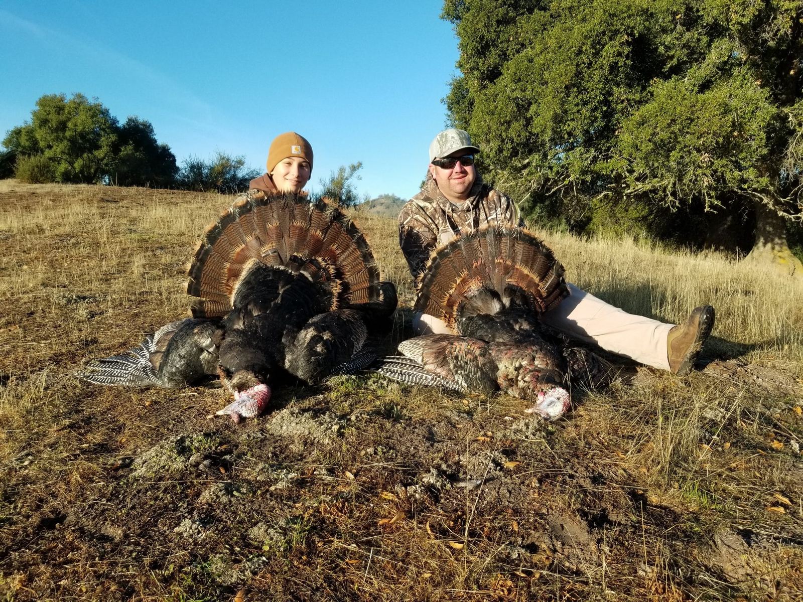 Two hunters with a pair of Rio Grande toms in the field